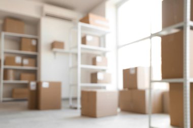 Raf birimleri ve karton kutularla dolu bulanık depo görüntüsü