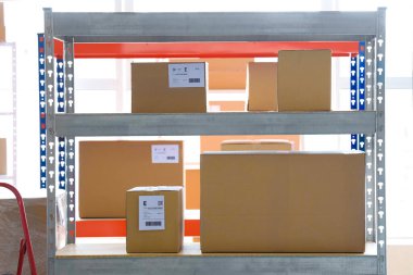 Deposunda karton kutular olan raf ünitesi.