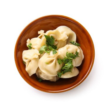 Beyaz arka planda maydanozlu bir kase lezzetli haşlanmış hamur köftesi.