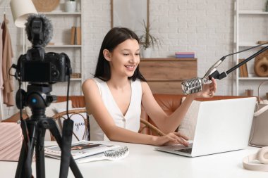 Evde mikrofon ve laptop kayıt videosu olan genç blogcu