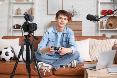 Oyun blogcusu evdeki kanepede video kaydediyor.