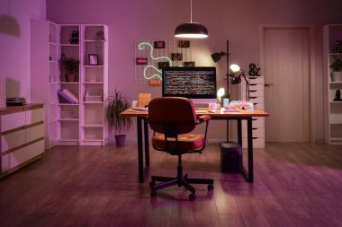 İşyeri ve geceleri parlayan lambaları olan karanlık programcı ofisinin içinde.