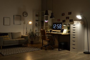 Geceleri karanlık programcı bürosunun çalışma odası, çivi tahtası ve parlayan lambaları.