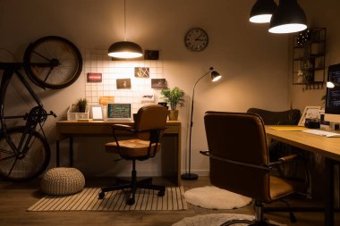 Geceleri masaları, bisikletleri ve parlayan lambaları olan karanlık programcılar ofisi.