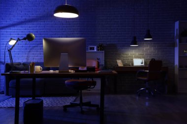 Geceleri masaları, kanepesi ve parlayan lambaları olan karanlık programcı ofisinin içinde.