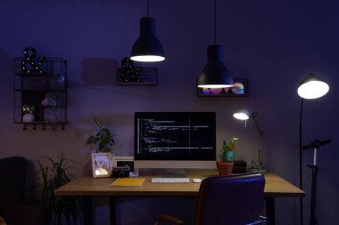 İşyeri ve geceleri parlayan lambaları olan karanlık programcı ofisinin içinde.