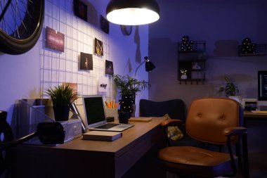 Geceleri karanlık programcı ofisi, çalışma yeri, çivi tahtası ve parlayan lamba.