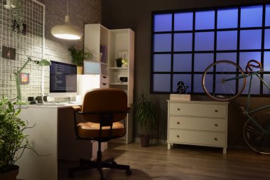 Geceleri karanlık programcı bürosunun çalışma odası, çivi tahtası ve parlayan lambaları.