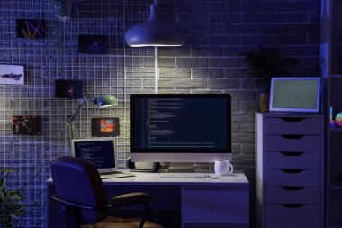 Geceleri karanlık programcı ofisi, çalışma yeri, çivi tahtası ve parlayan lamba.