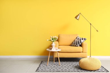 Interior of living room with yellow armchair, table and lamp