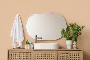 Çiçek açan vazolar kozmetik ürünler ve havlular şık banyodaki lavabonun yanında.