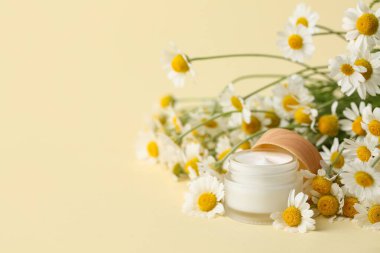 Doğal krema kavanozu ve güzel papatya çiçekleri.