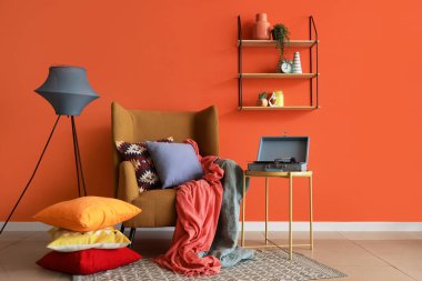 Koltuklu, yastıklı ve pikaplı bir oturma odası.