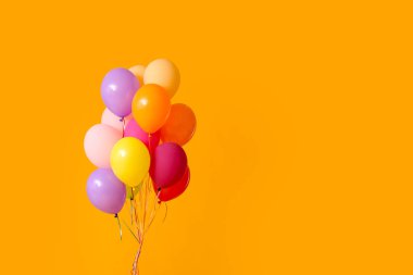 Turuncu arka planda renkli hava balonları