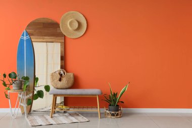 Yumuşak bank, ayna ve sörf tahtasıyla şık bir koridor.