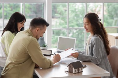 Ofiste çiftler için anlaşma imzalayan Asyalı kadın emlakçı