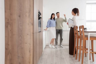 Yeni dairelerinde anahtar ve emlakçı olan mutlu genç çift.