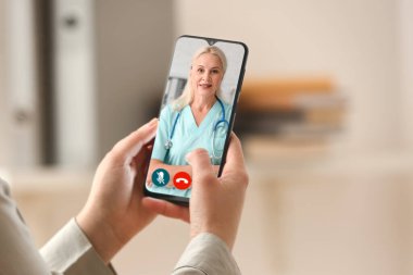 Woman using modern mobile phone in office, closeup