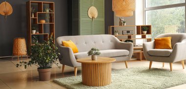 Gri kanepesi, koltuğu ve ahşap sehpası olan modern oturma odasının içinde.