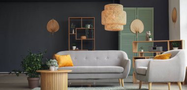 Gri kanepesi, koltuğu ve ahşap sehpası olan modern oturma odasının içinde.