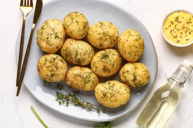 Beyaz arka planda dereotlu ve soslu haşlanmış bebek patatesleri.