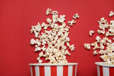 Kırmızı arka planda lezzetli patlamış mısır kovaları