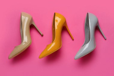 Pembe arka planda farklı yüksek topuklu ayakkabılar.
