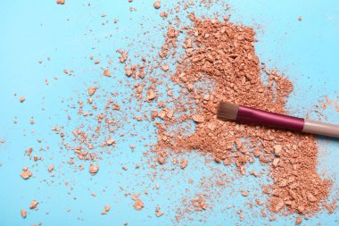 Mavi arka planda makyaj fırçası ve dağınık fosforlu kalem