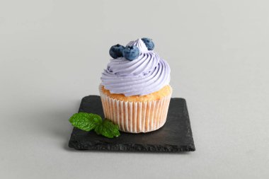 Gri arka planda yaban mersinli lezzetli kekler.