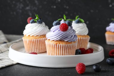 Böğürtlenli, ahudutlu ve siyah arkaplanlı lezzetli çörekler.