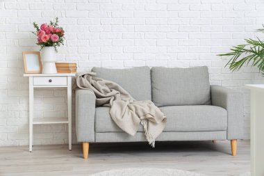 İçinde kitaplar ve oturma odasındaki komodinin çerçevesi olan güzel pembe yıldız çiçekleri vazosu.