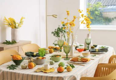 Çiçekler, yapraklar ve balkabaklarıyla sonbahar masası