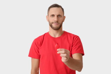 Beyaz arka planda kırmızı kurdeleli genç adam. AID farkındalık kavramı