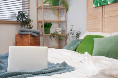 Yatak odasında dizüstü bilgisayar, yakın plan.