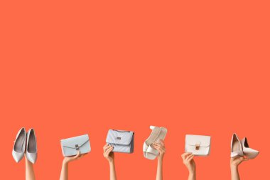 Turuncu arka planda şık ayakkabılı ve çantalı kadınlar.