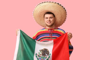 Pembe arka planda Meksika bayrağı olan, Sombrero 'lu yakışıklı genç adam. Cinco de Mayo kutlaması