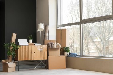 Karton kutular, çekmeceler ve taşınma gününde güzel bir odada saksılar.