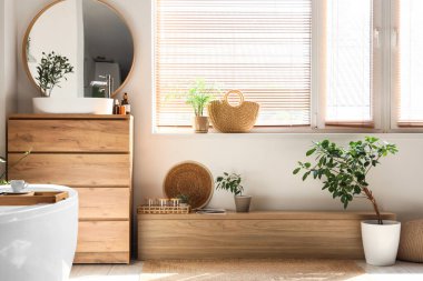 Lavabosu, küveti, çekmecesi ve aynası olan şık bir banyo.