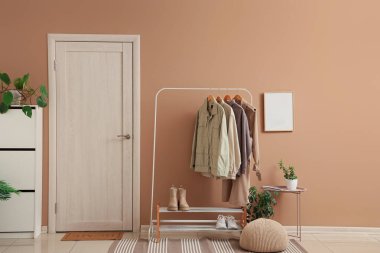 Koridorun içinde elbise askısı, çekmece ve kapı var.