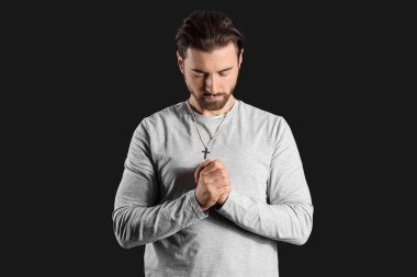 Dindar adam siyah arka planda dua ediyor.