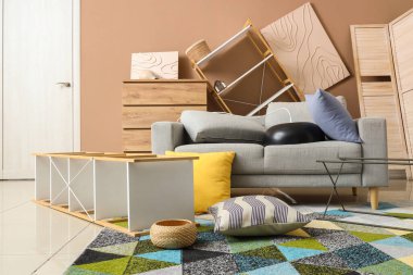 Depremden sonra mobilyaların devrildiği dağınık bir oturma odası.