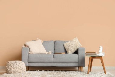 Odadaki bej duvarın yanındaki cam masanın üzerinde bir yığın eski kitap var.