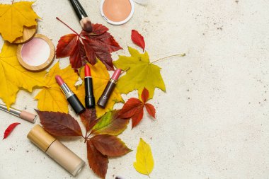 Dekoratif kozmetik ürünleri ve arka planda düşmüş yapraklarla kompozisyon