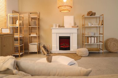 Şöminesi, rafları ve lambası olan rahat bir oturma odası.