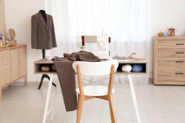 Terzinin dikiş makinesi, farklı malzemeler ve atölye mankeni.