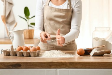 Mutfak tezgahında hamur hazırlayan kadın.