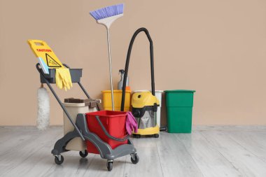 Temizlik malzemeleri ve bej duvarın yanında elektrikli süpürge olan bir tramvay.