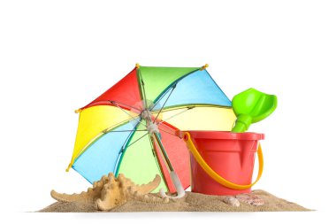 Beyaz arka planda plaj oyuncakları, şemsiye ve kum