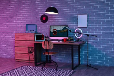 Podcaster 'ın iş yeri, tuvaleti ve parlayan lambası olan karanlık stüdyonun içi.