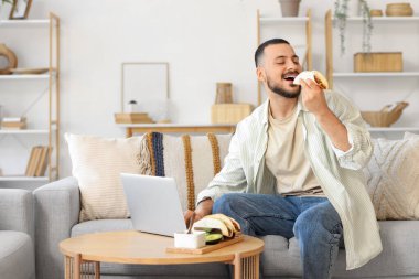 Genç adam evde lezzetli tacolar yiyor.